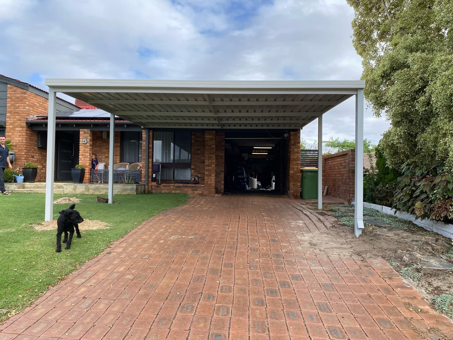 Double bay flat roof steel carport over brick driveway in Perth, WA