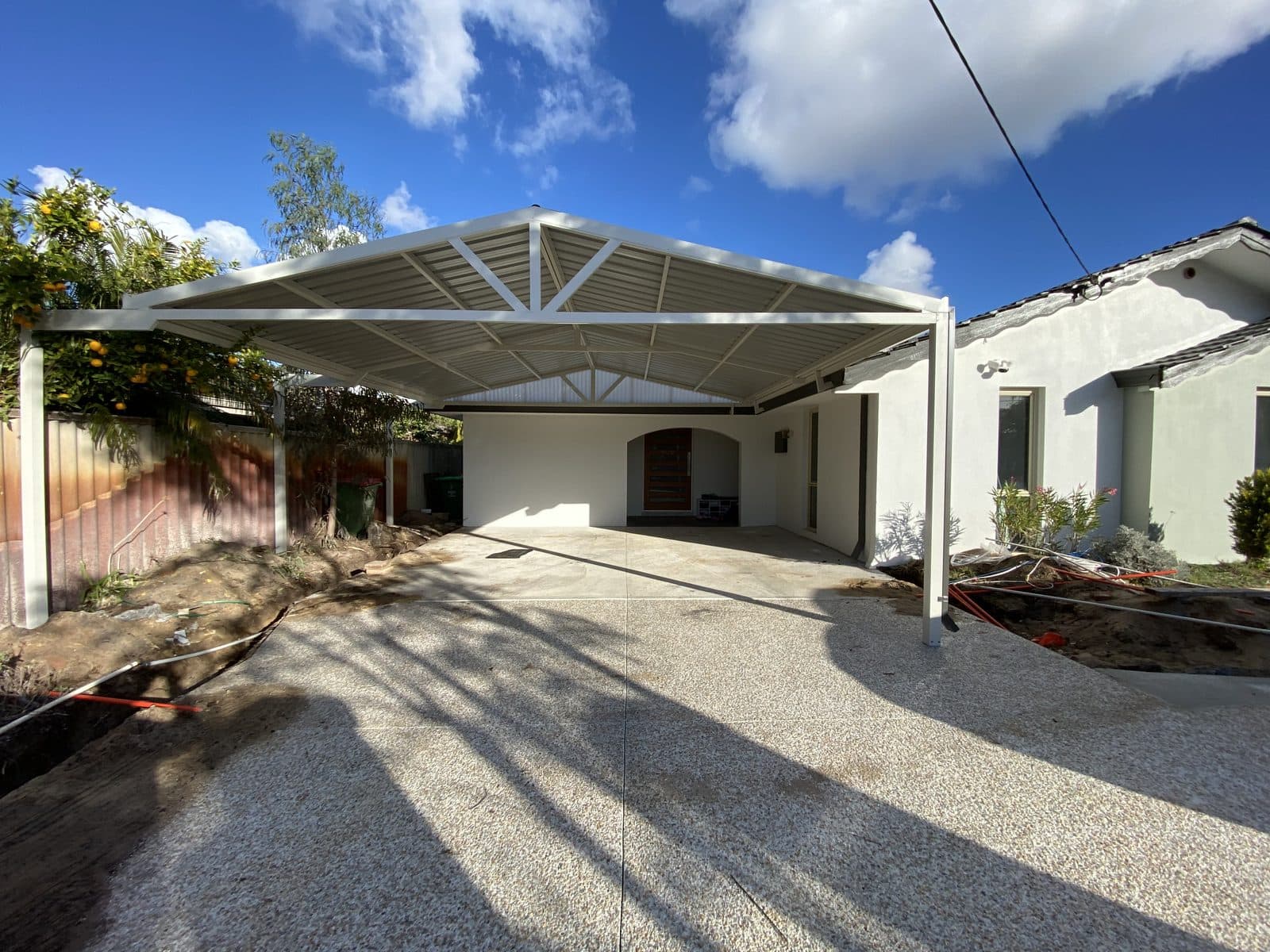 Gable carport with exposed steel trusses over a new aggregate driveway in Perth, WA