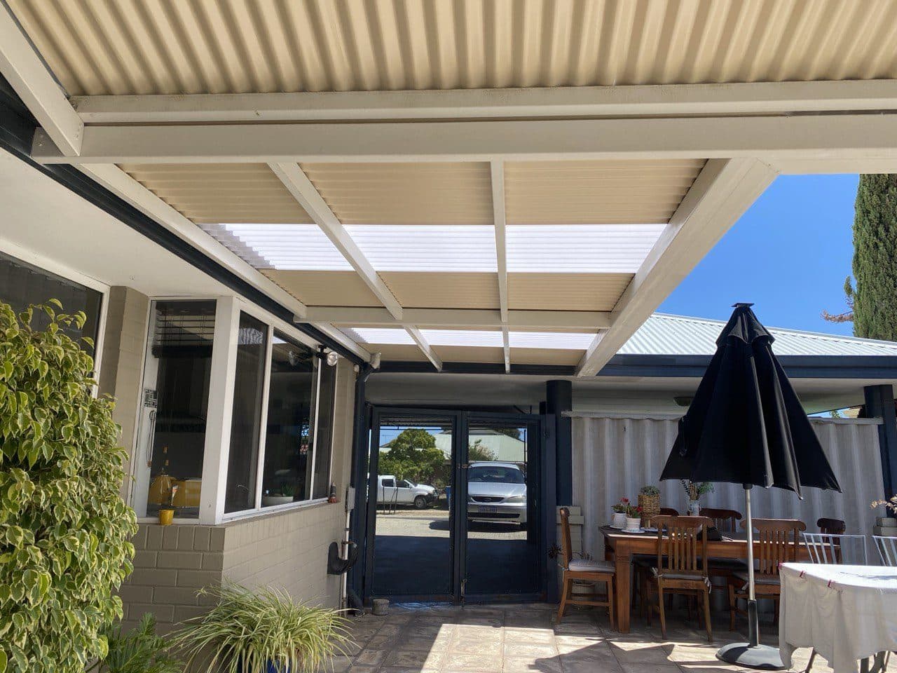 Flat roof patio over a furnished outdoor dining area with umbrella at a Perth home