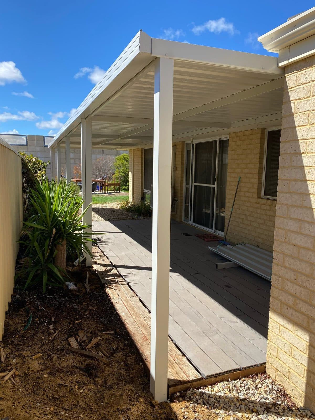 Flat roof patio with timber-look decking along the side of a rendered Perth home